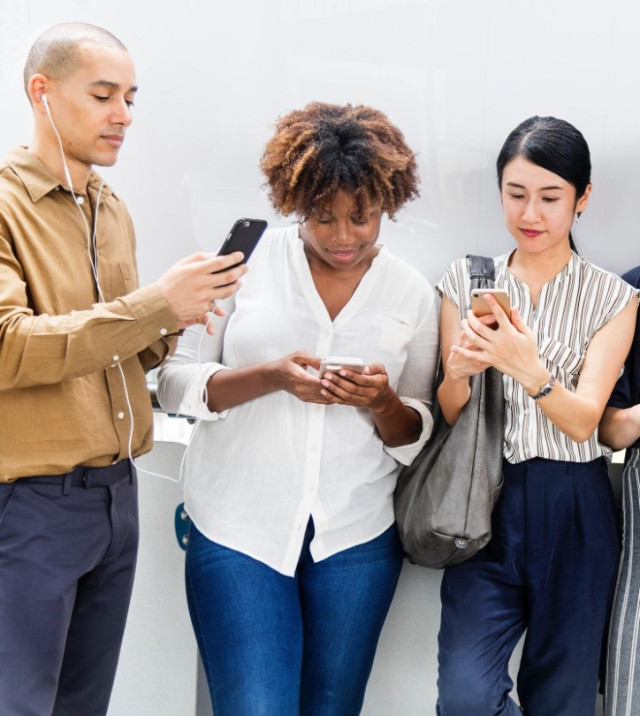 Three women playing with their mobiles